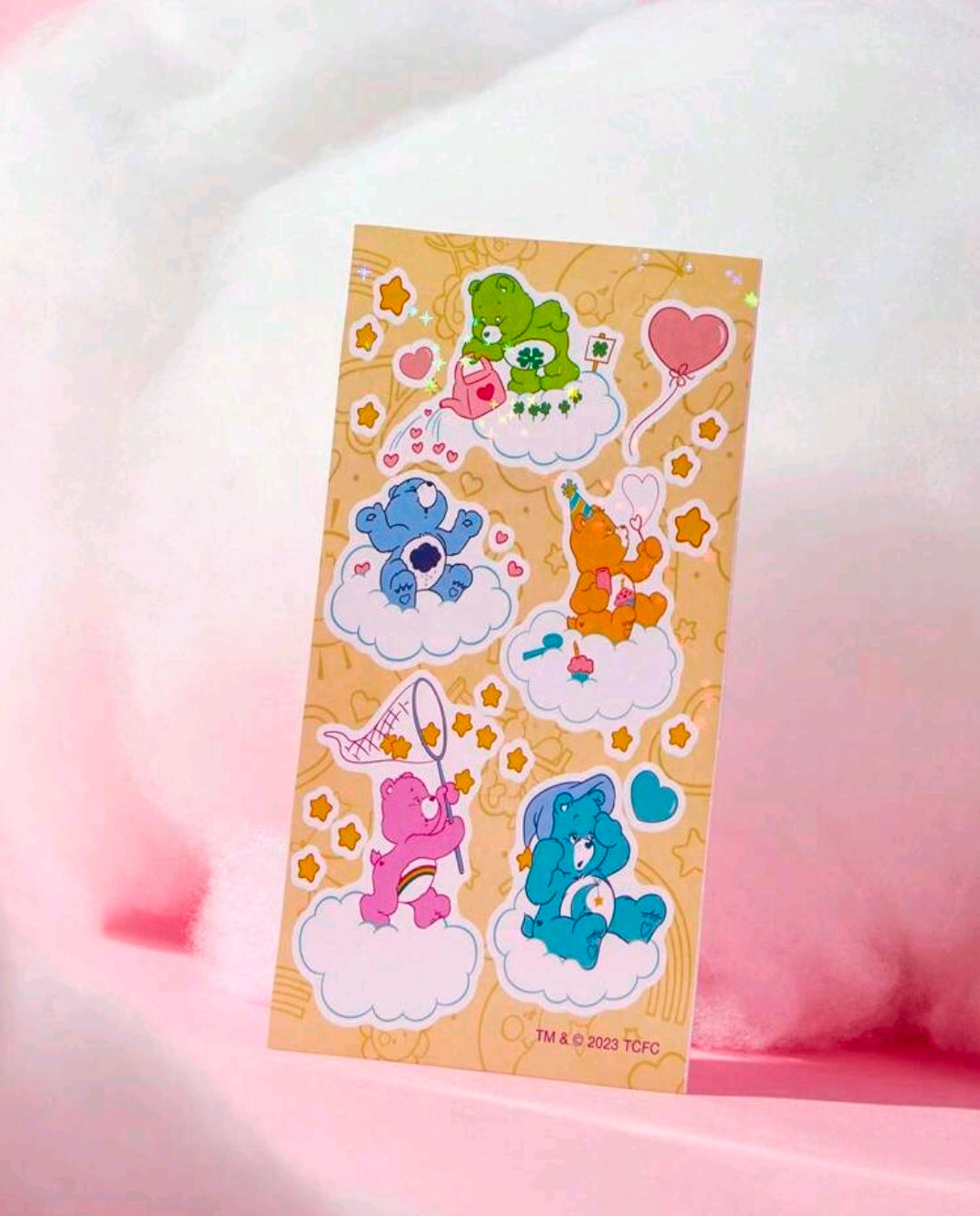 Holographic sticker sheet with Care Bears scenes, hearts, clouds, and colorful characters