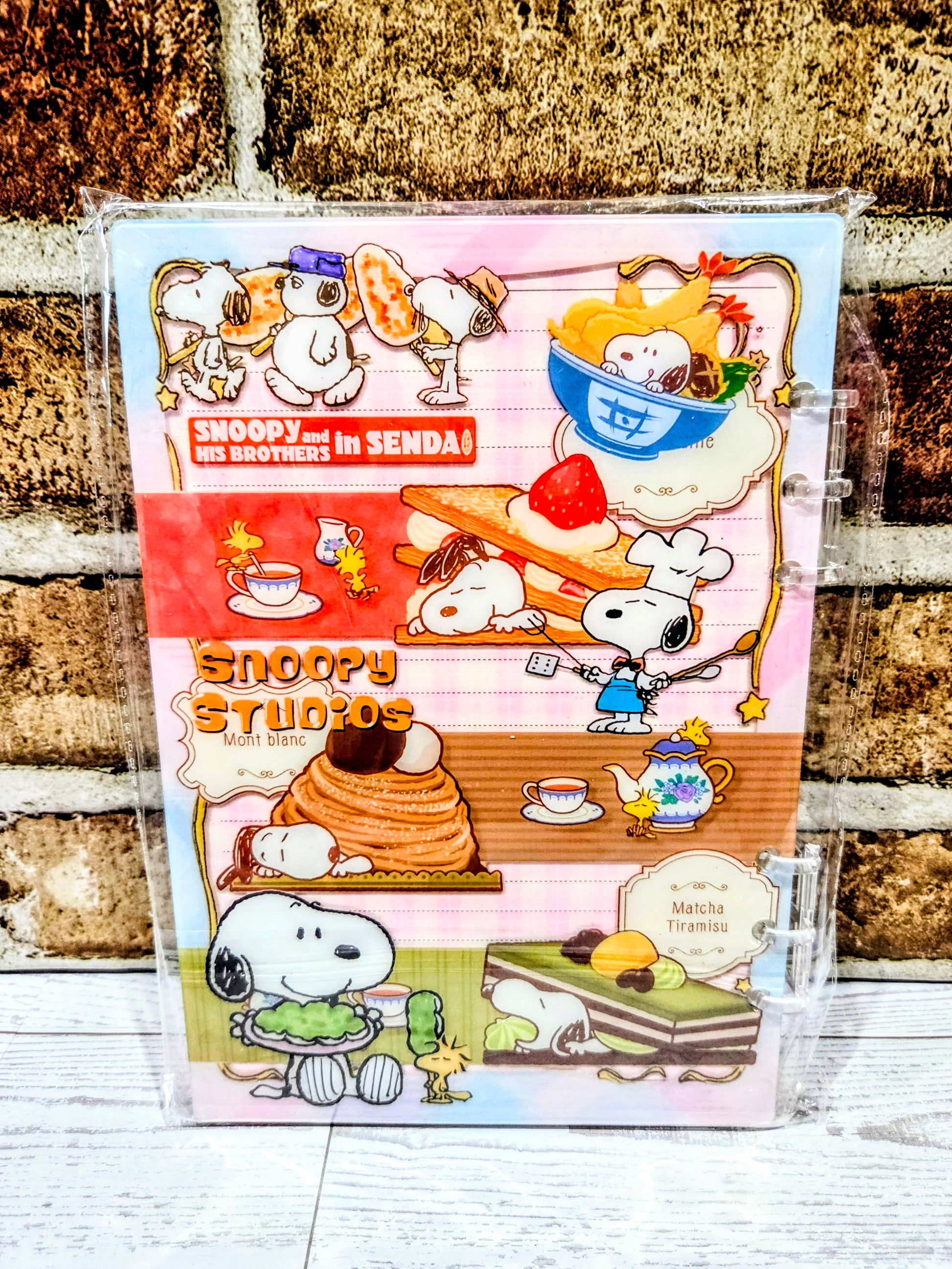 A5 acrylic shaker notebook with Snoopy Studio food scenes on a pink-and-orange cover.