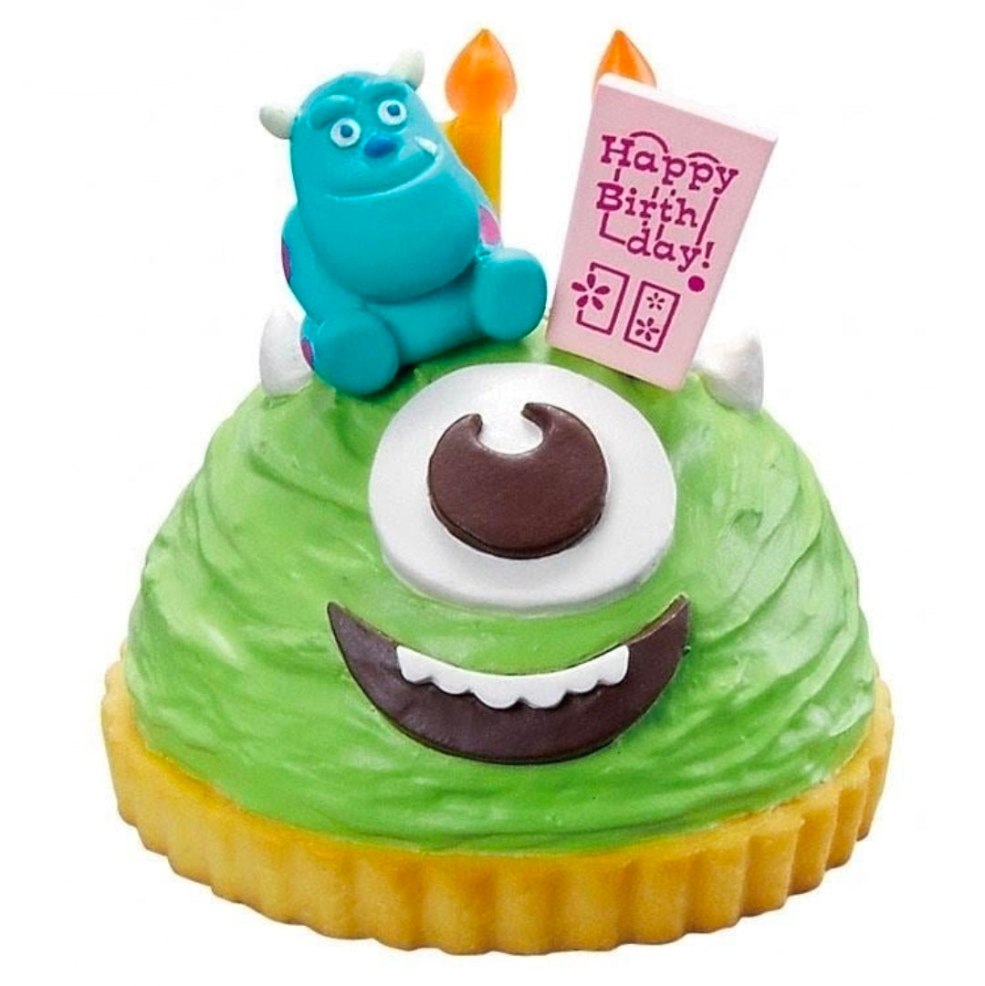 Close-up of green sponge cake mini figure with teal Sulley holding Happy Birthday card