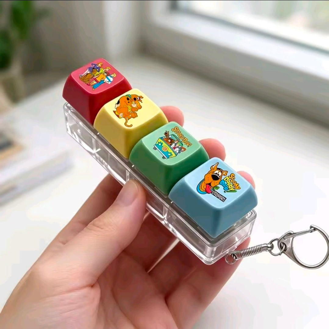 Four acrylic keycap fidgets with colorful Scooby-style caps and metal keychain spring