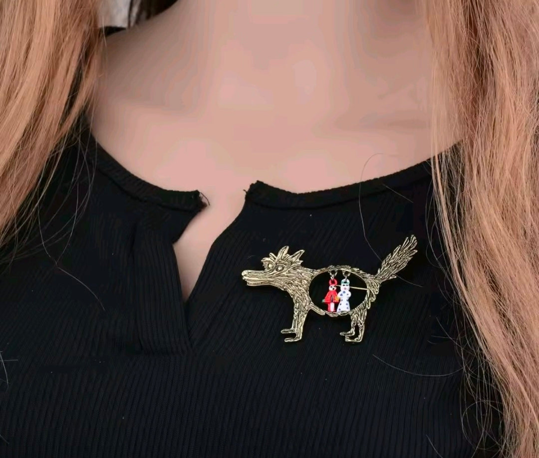 Wolf brooch pin on black top: gold-tone enamel wolf with circular Red Riding Hood charms.