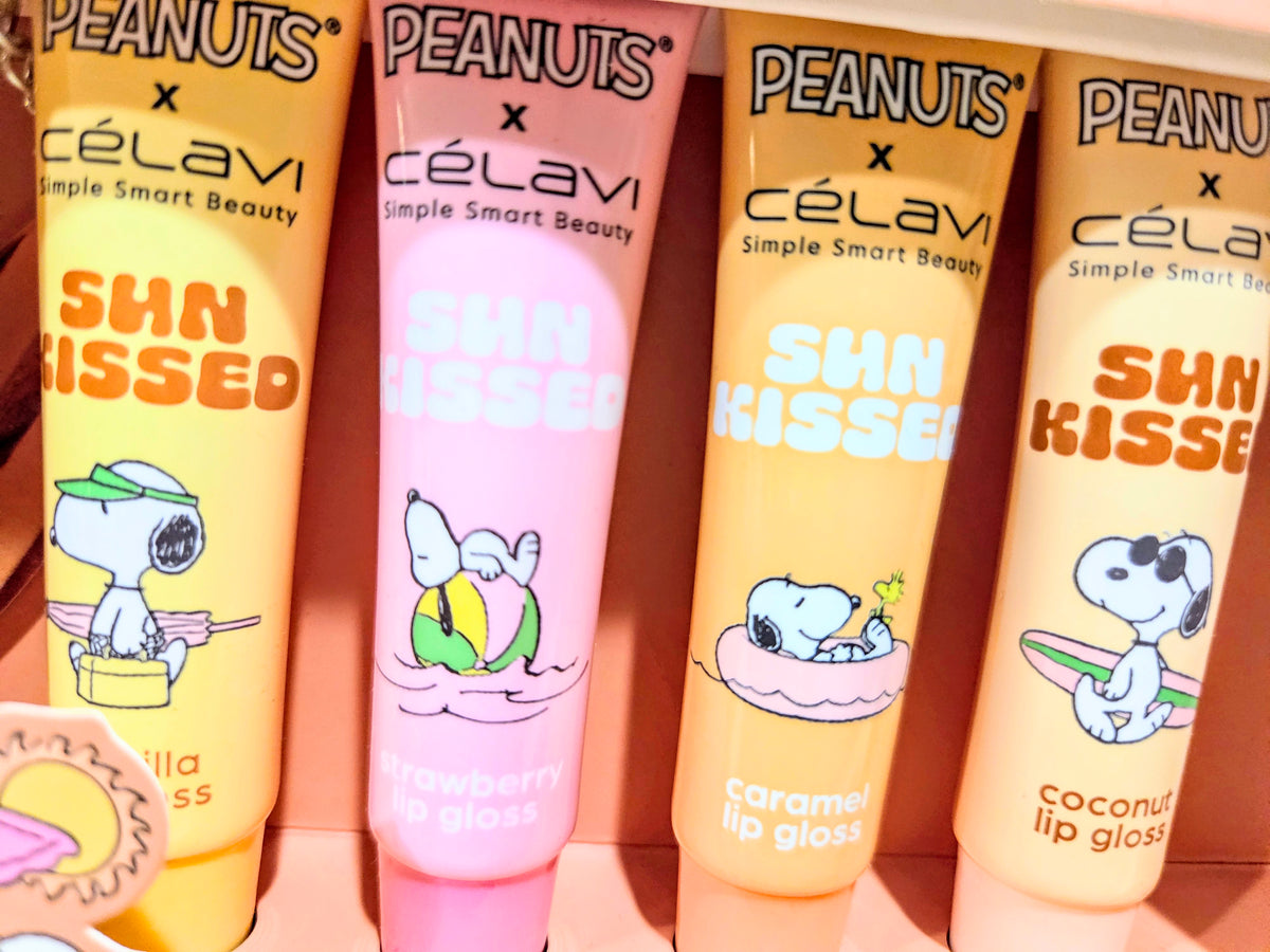 Four Sun Kissed lip gloss tubes with Peanuts themed labels and shade colors