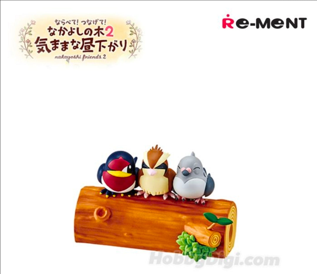 Three small toy animals—dark bird, yellow bird, and gray bird—on a brown log.