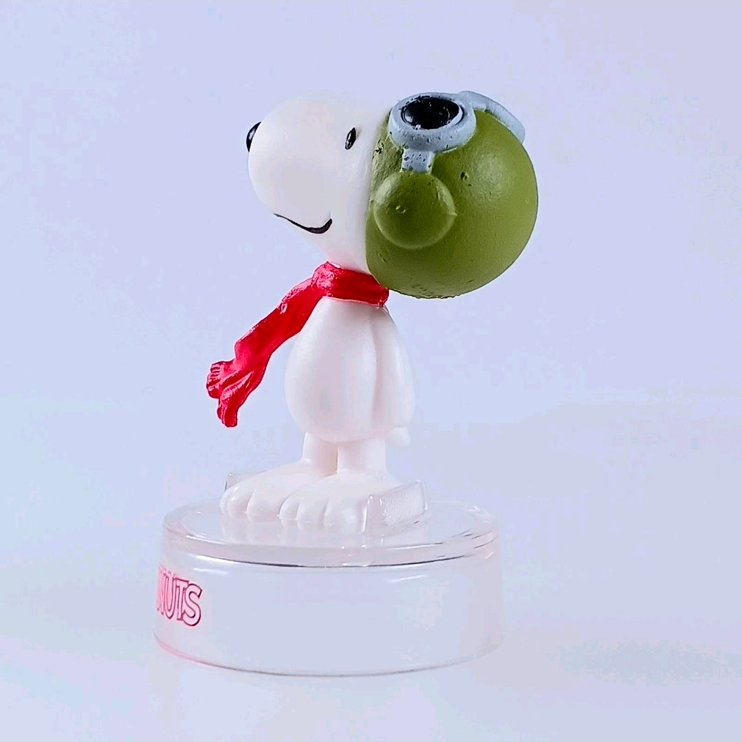 Snoopy figure with green bird head and red scarf, clear PEANUTS base