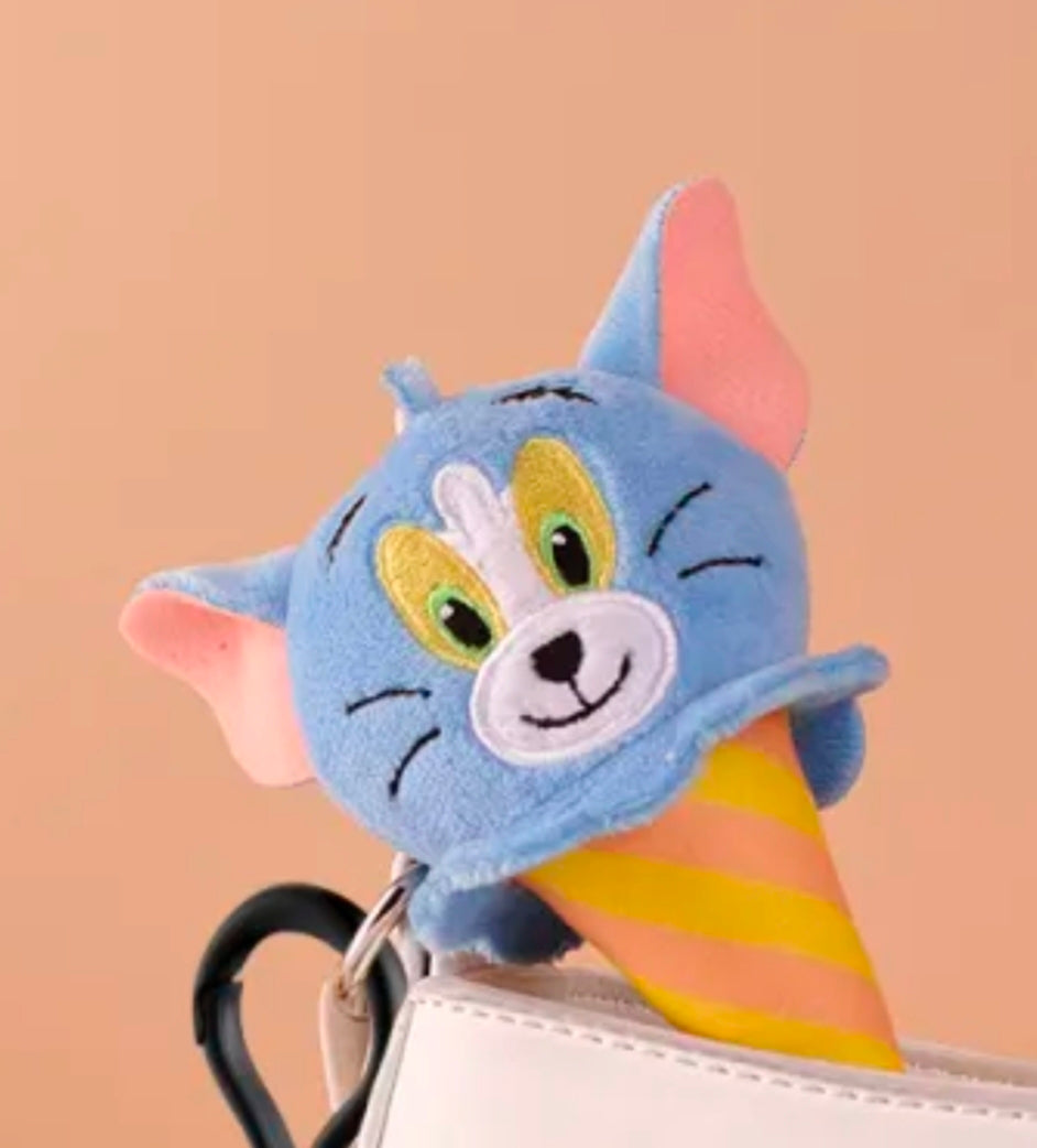 Close-up Tom cat plush keychain head with green eyes and yellow striped ice cream cone