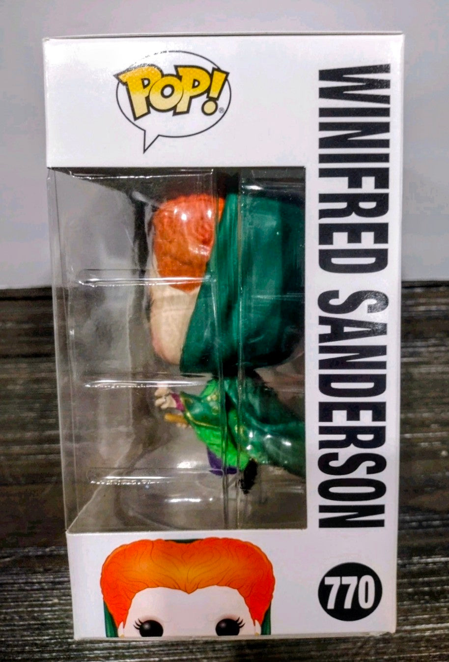 Boxed Funko Pop vinyl figure side view, orange hair and green outfit visible