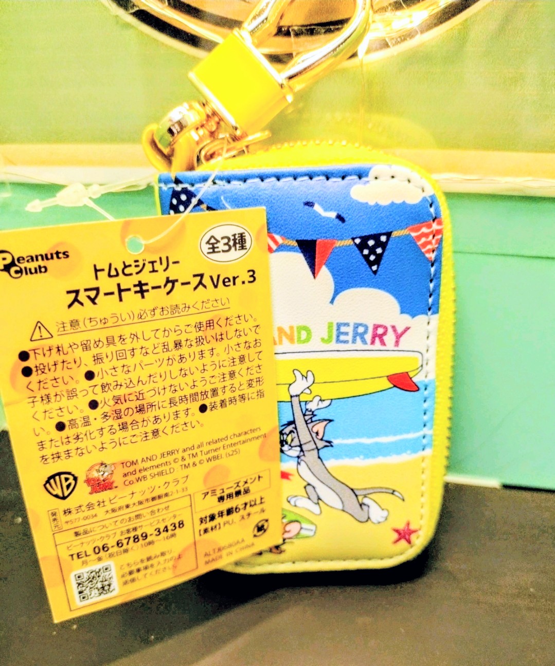 Blue smart key case with yellow zipper and Tom and Jerry artwork on the front