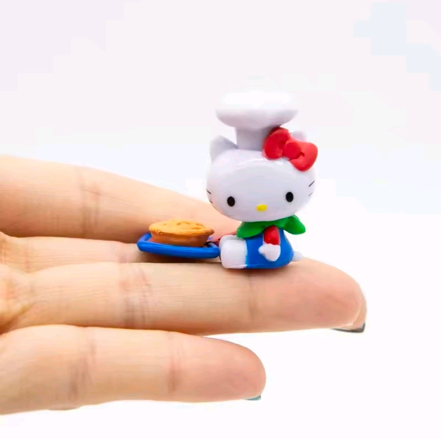 Hello Kitty mini figure on a blue base, shown in hand with snack accessories