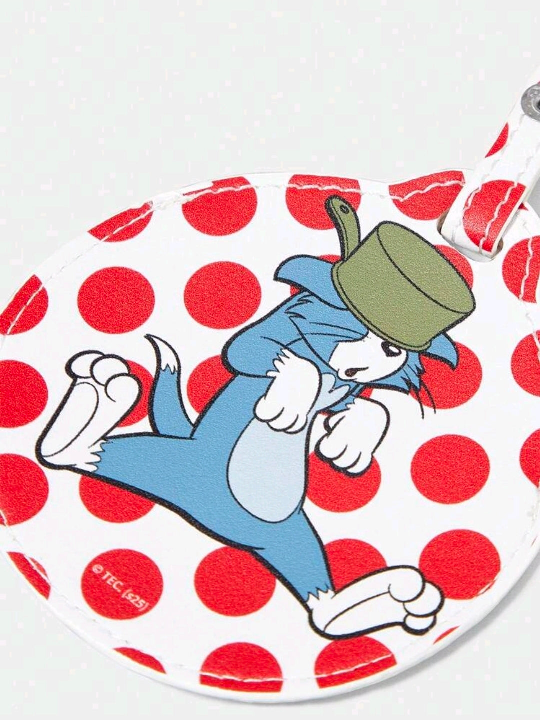 Round fabric bag charm featuring a blue cat holding a cane, red polka dot background