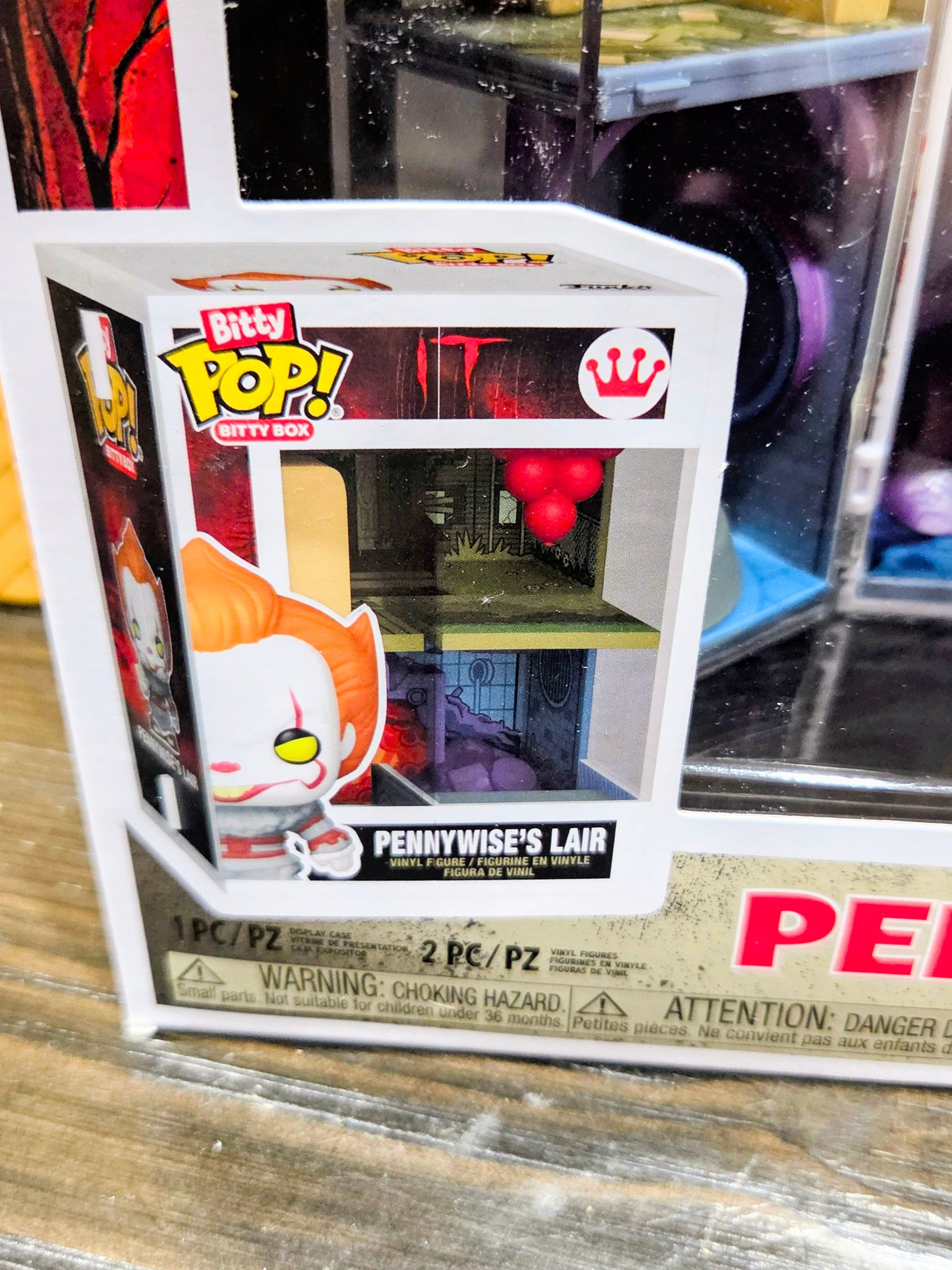 Packaged Bitty Pop! figure window box with white clown face and red crown icon