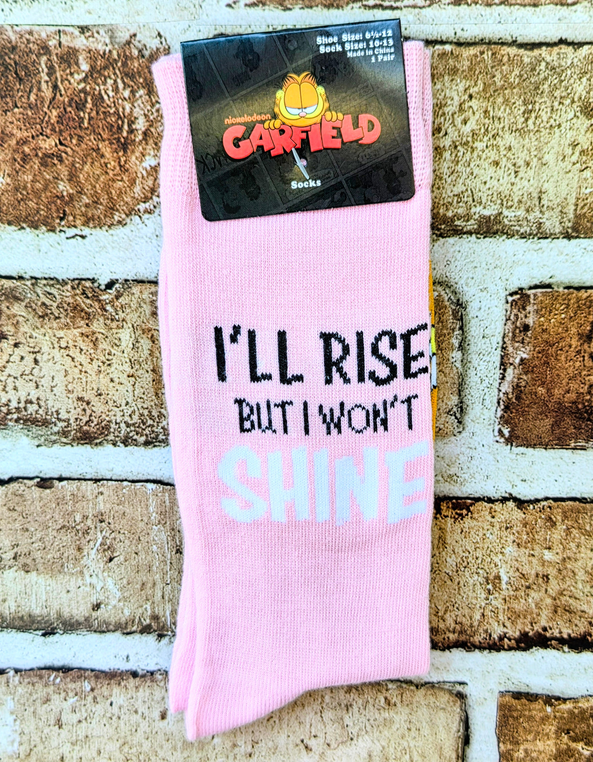 Pink Garfield crew socks featuring 'I'll Rise But I Won't Shine' text.
