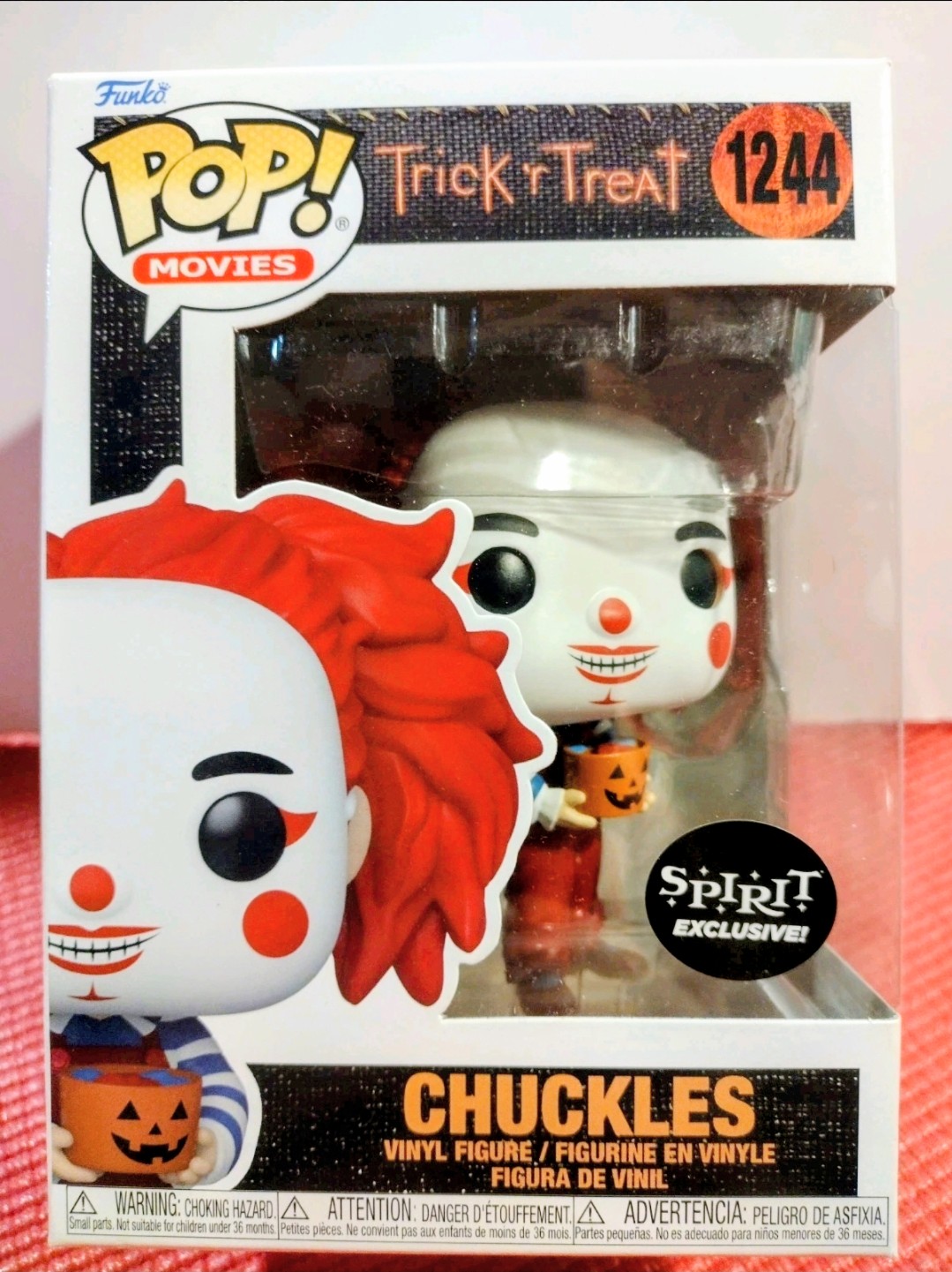 Boxed vinyl Pop! figure: white clown face, red hair, holding a small pumpkin