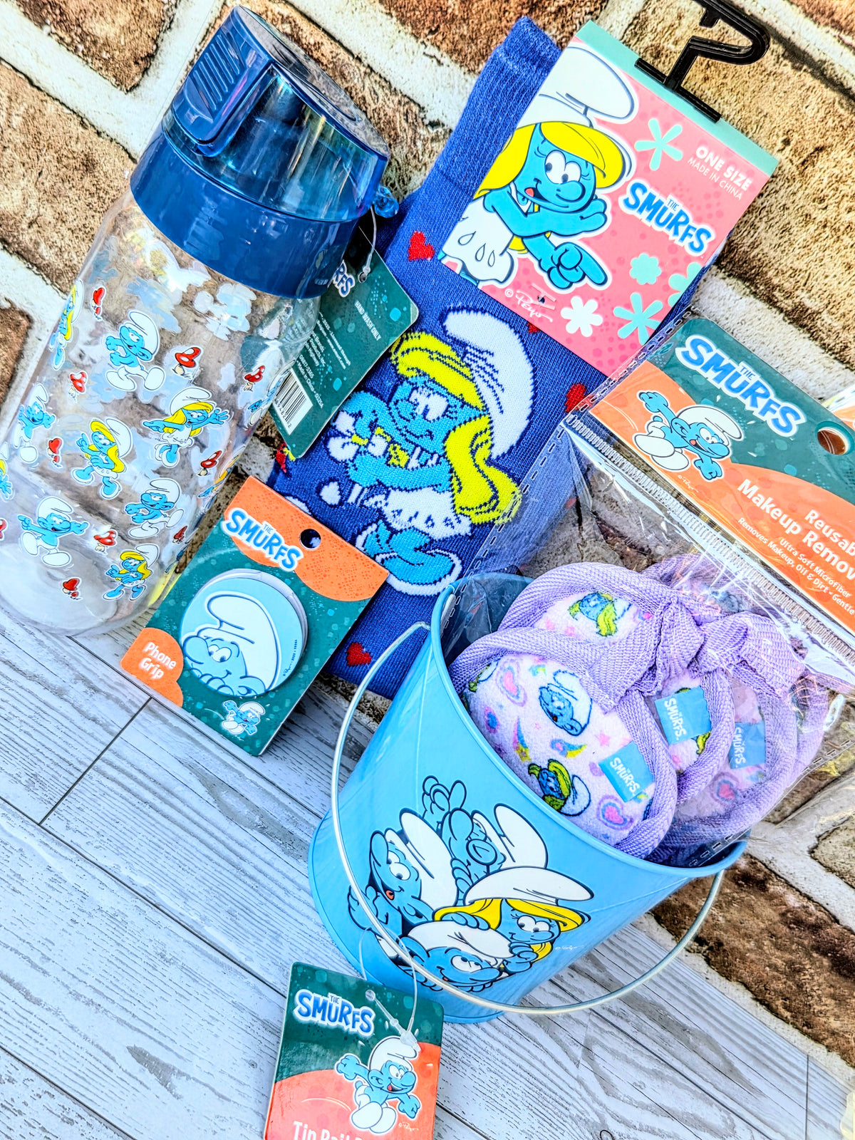 Smurfs gift set items: blue water bottle, socks, purple makeup remover pads