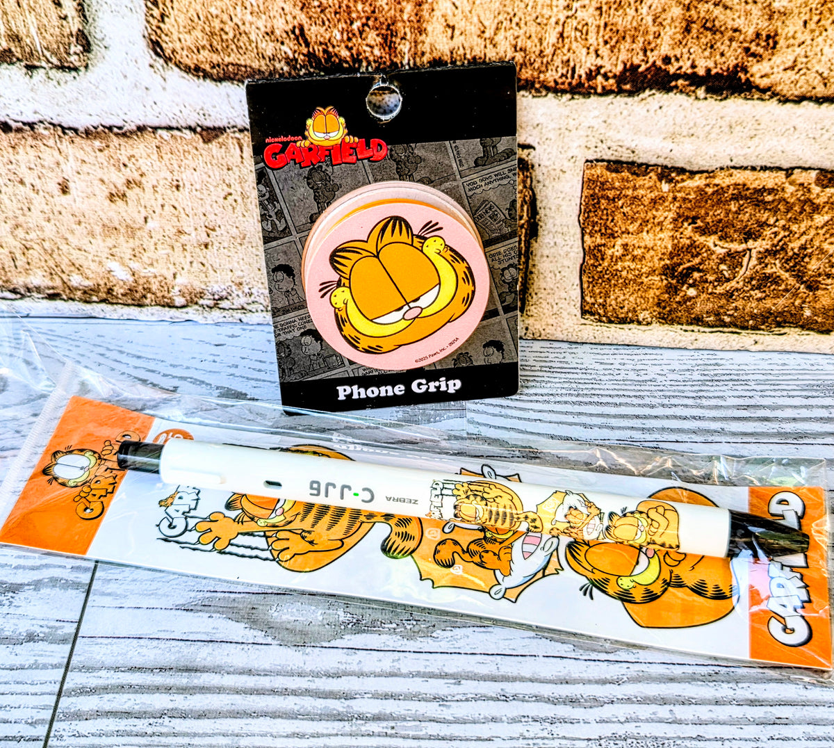 Garfield phone grip box with pink circular character graphic and orange character strip