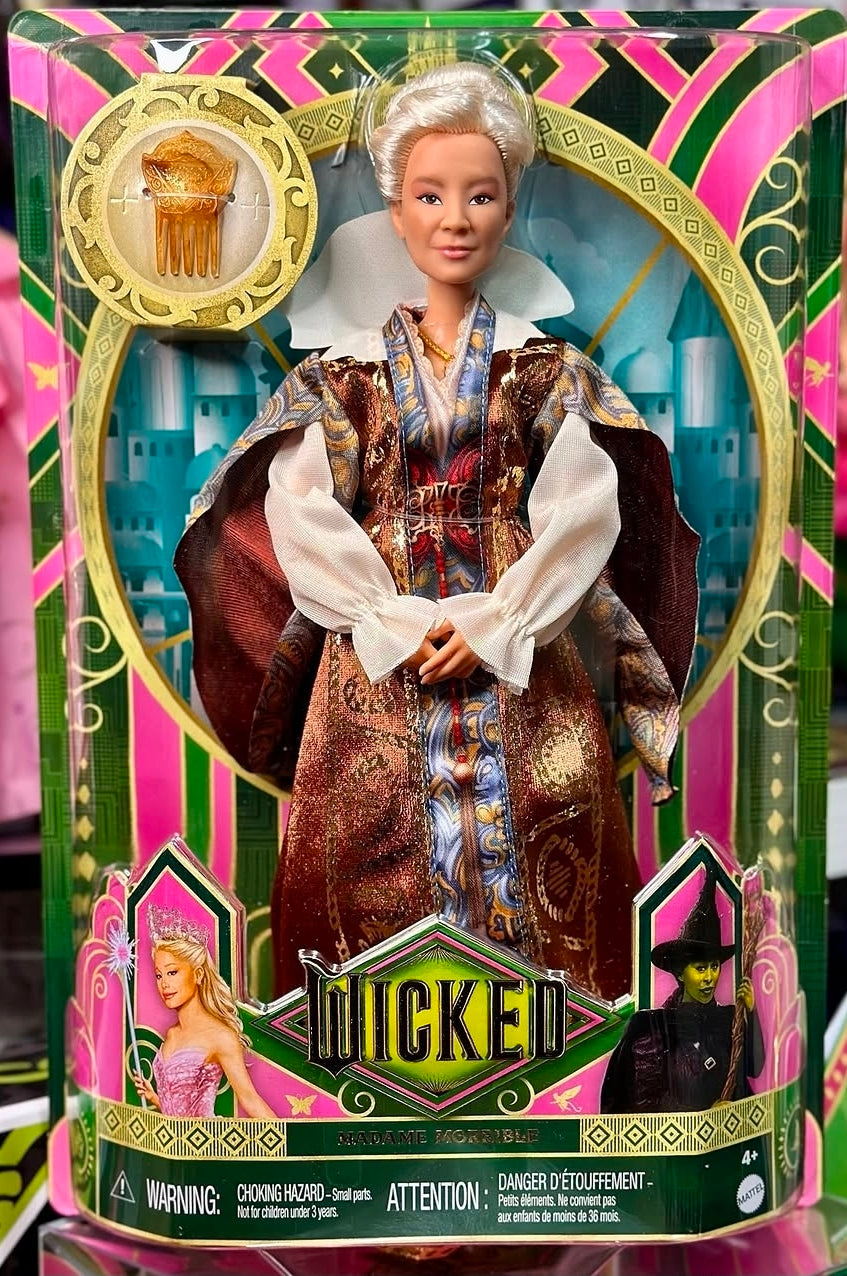 Fashion doll standing in maroon, gold, and blue patterned coat with white gloves and tiara.