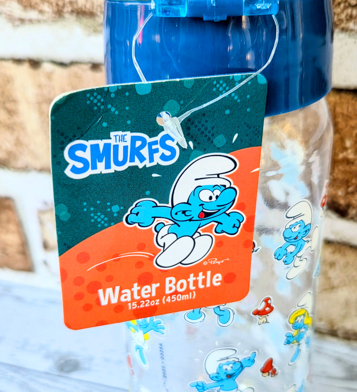 Clear water bottle with blue flip lid and 'Water Bottle' label with cartoon characters