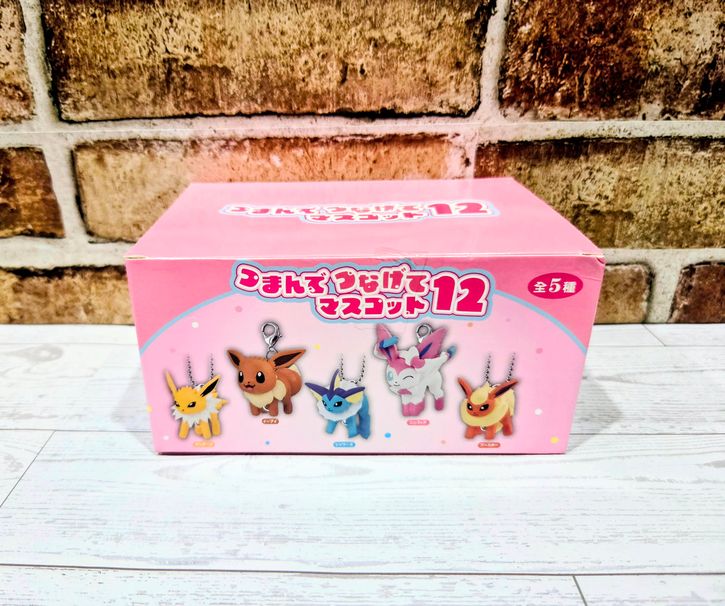 Pink keychain blind box showing five character charm figures on the front