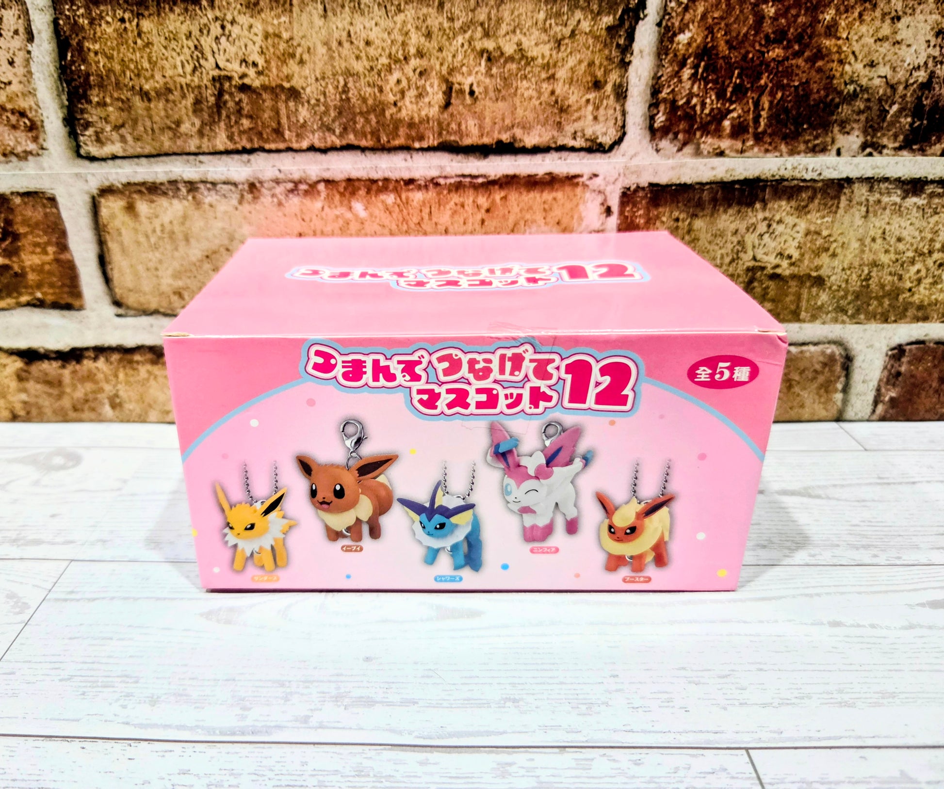 Pink keychain blind box showing five character charm figures on the front