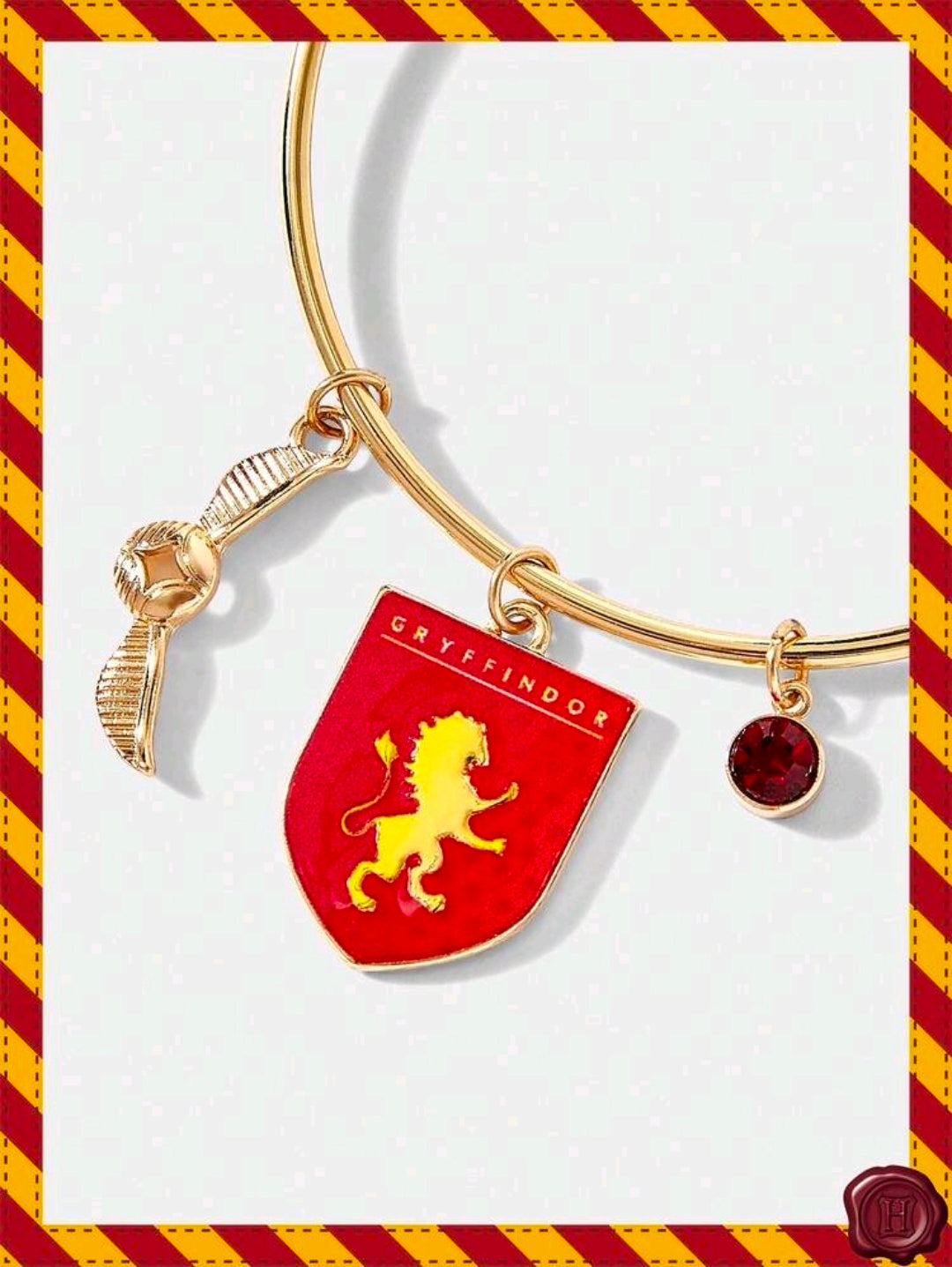 Gold-tone charm bangle with Gryffindor shield charm and red stone bead