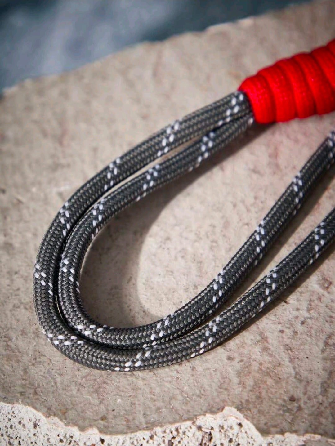 Black and silver lanyard cord with red connector bead, coiled textured weave