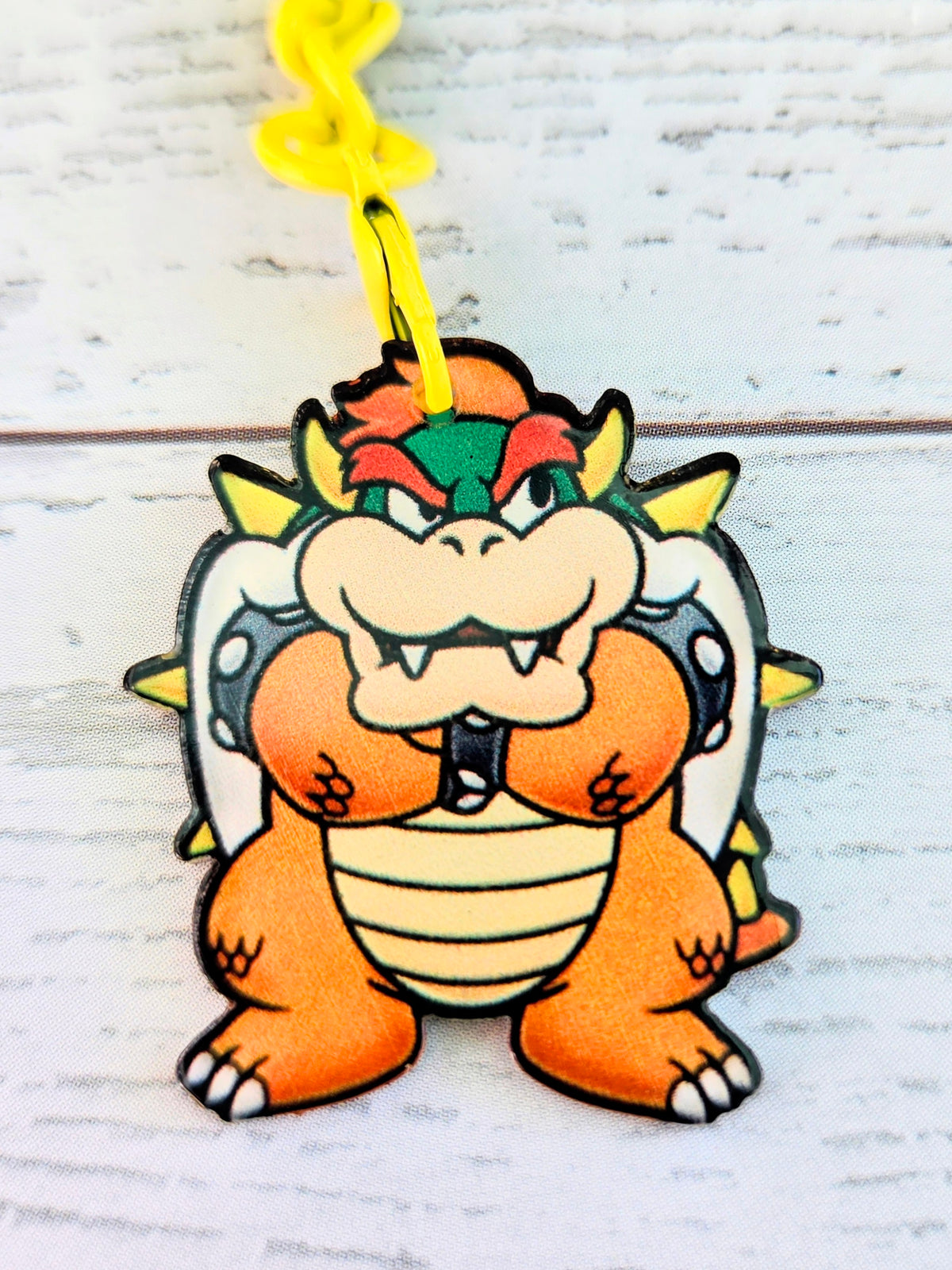 Bowser acrylic keychain with yellow ring, close-up standing face