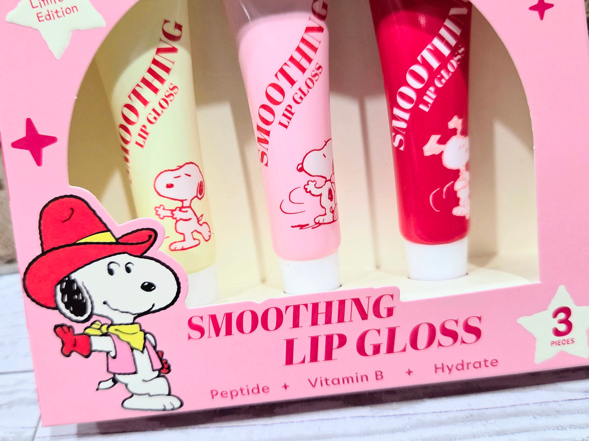 Three Snoopy smoothing lip gloss tubes displayed in a gift box