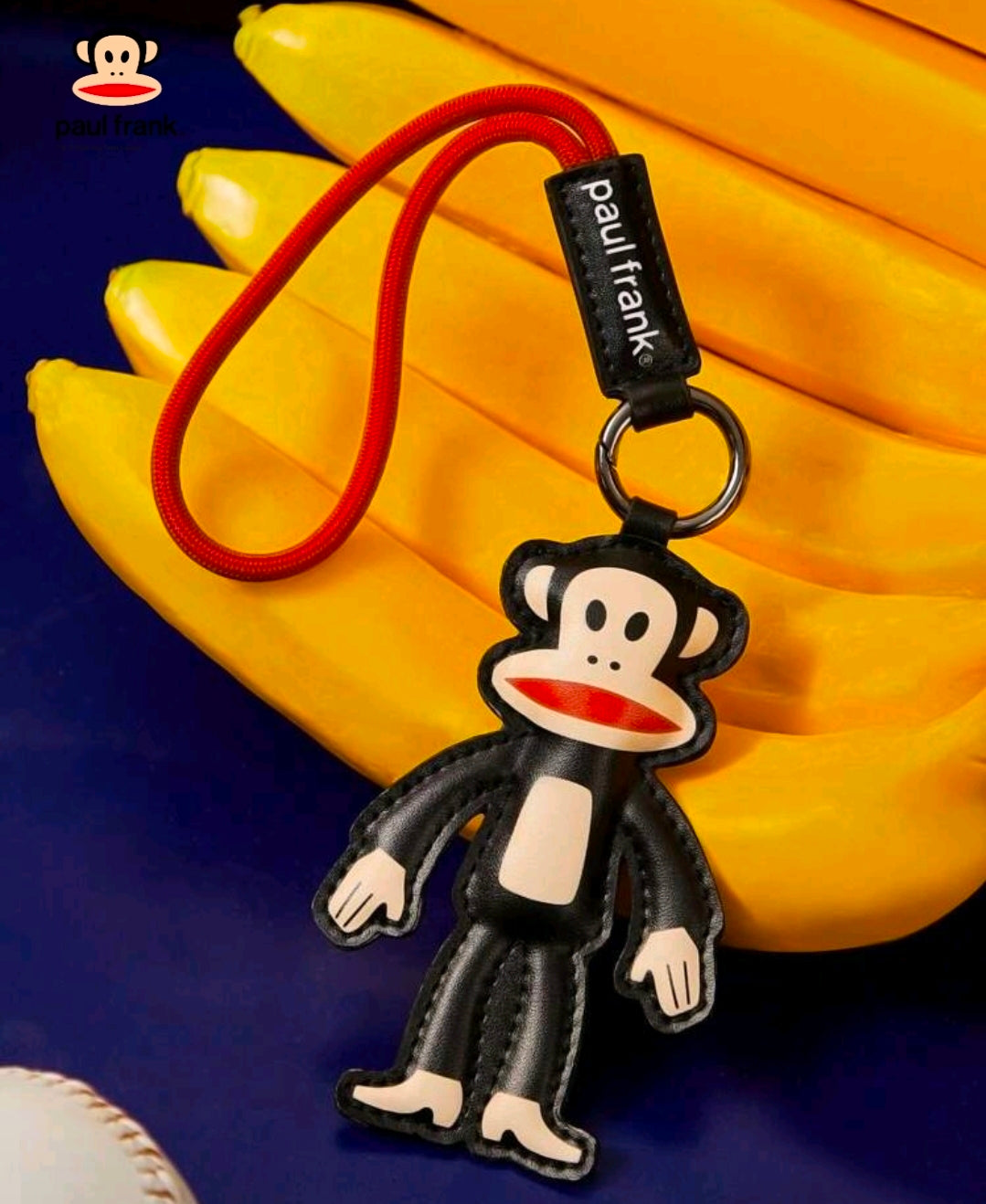 Julius monkey keychain charm on red lanyard with metal ring and faux-leather tag