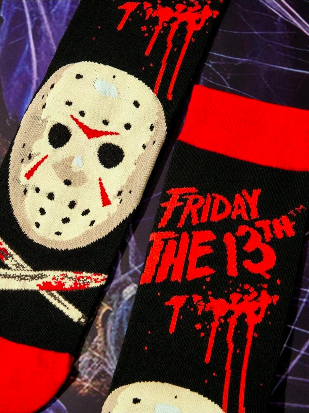 Close-up of black crew socks with red splatter text and hockey mask print