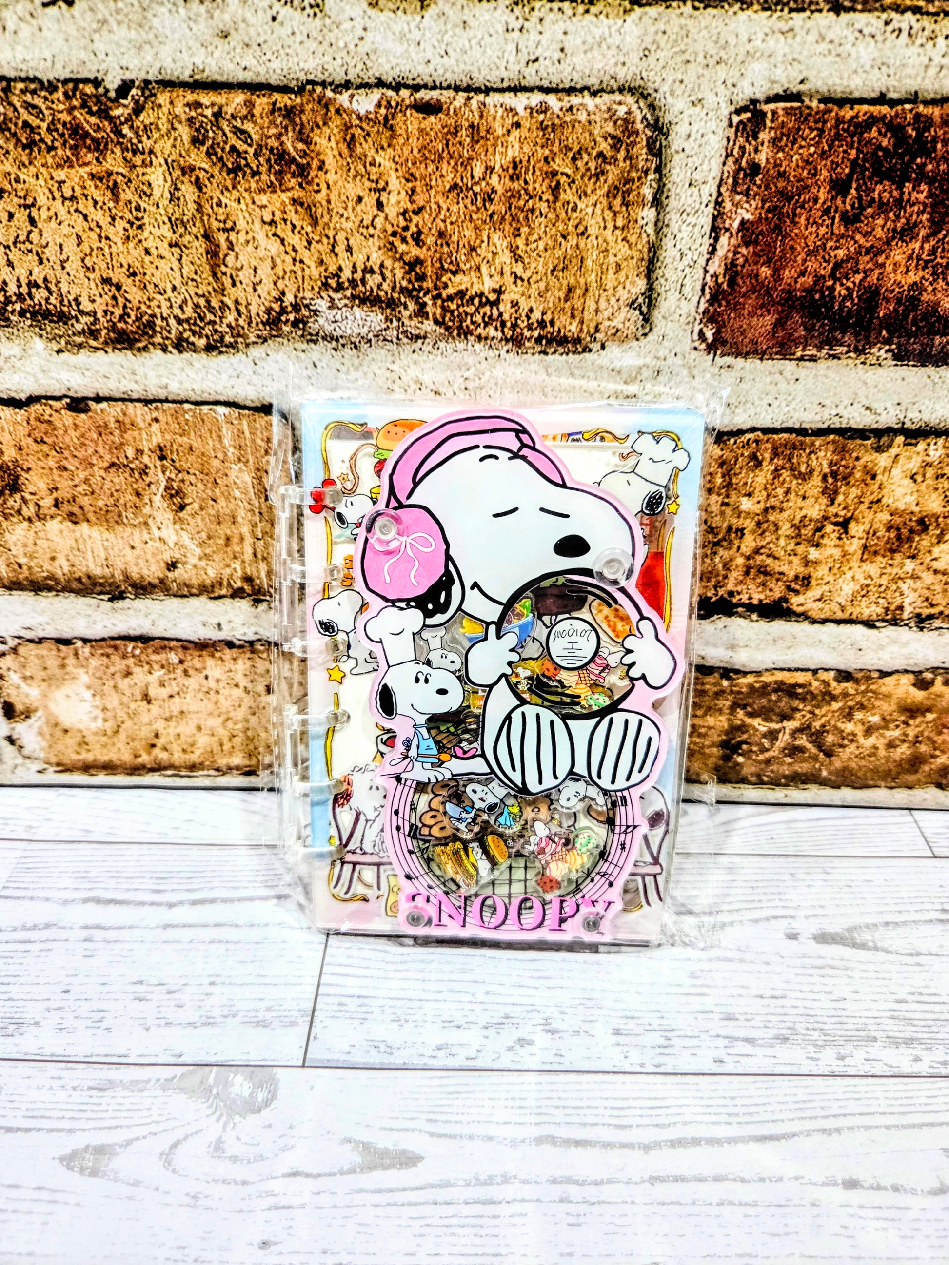 Pink acrylic shaker notebook with Snoopy chef character and food illustration cover