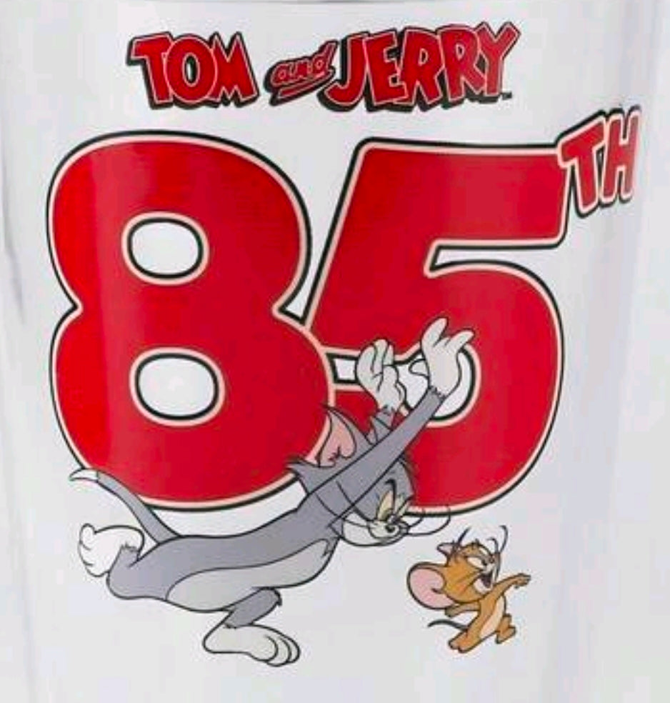 Clear tumbler close-up: red Tom & Jerry 85 logo graphic on glass