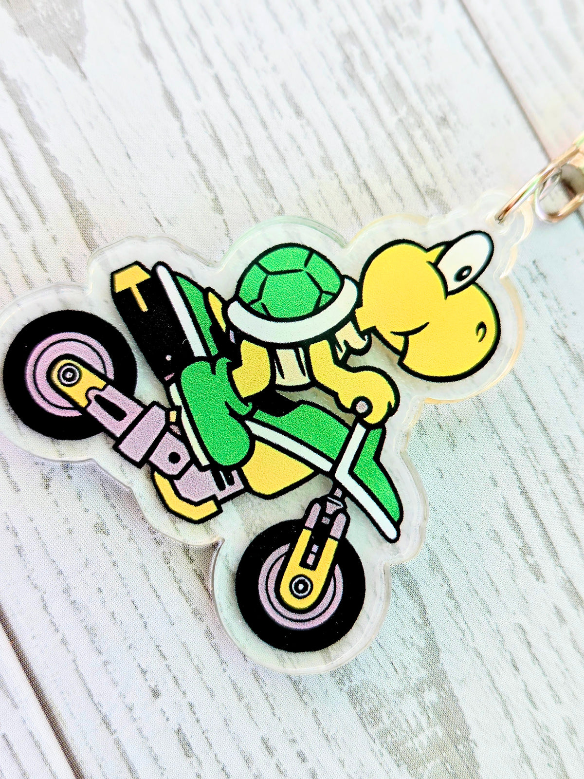 Acrylic keychain featuring Koopa Troopa on a green scooter with green shell