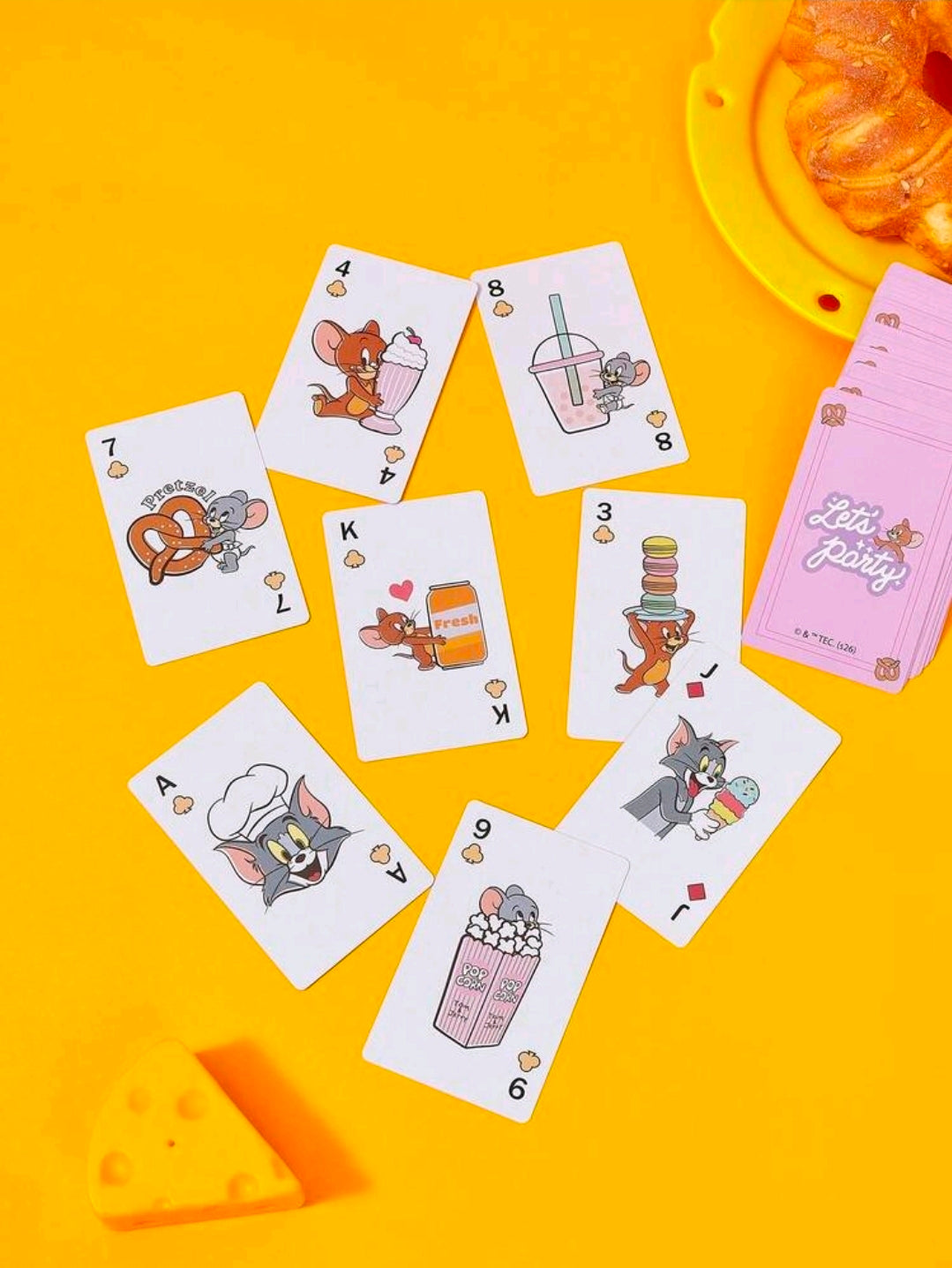 Assorted Tom & Jerry playing cards fanned on bright yellow background