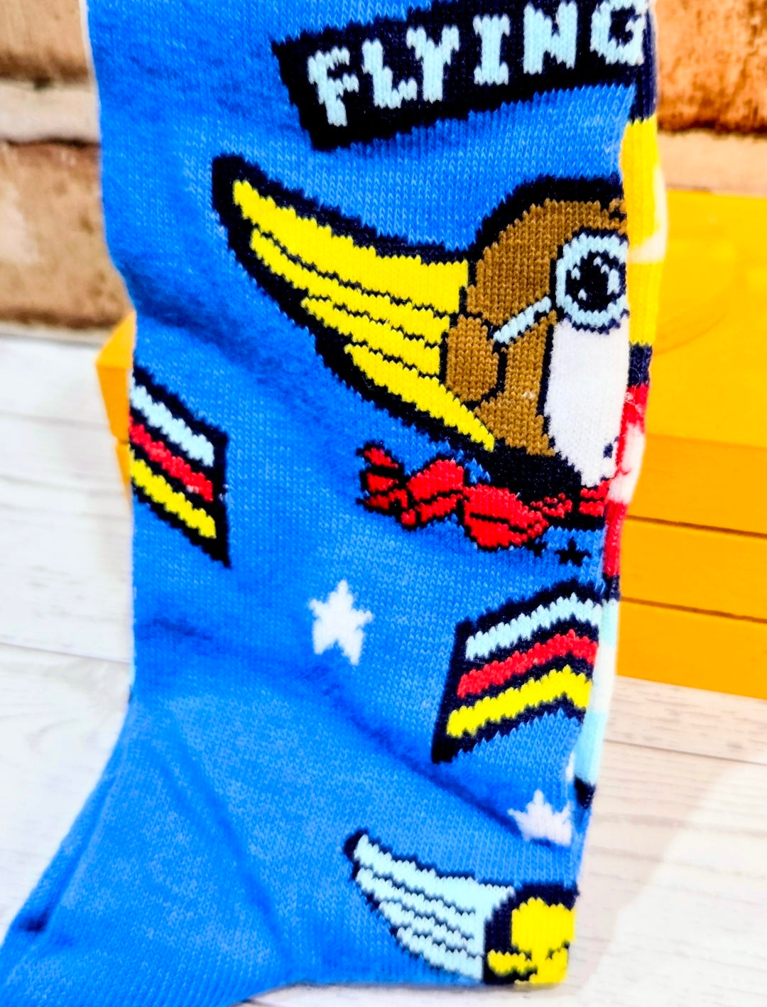 Blue crew sock detail with Snoopy flying ace face, “FLYING” text, and stripes