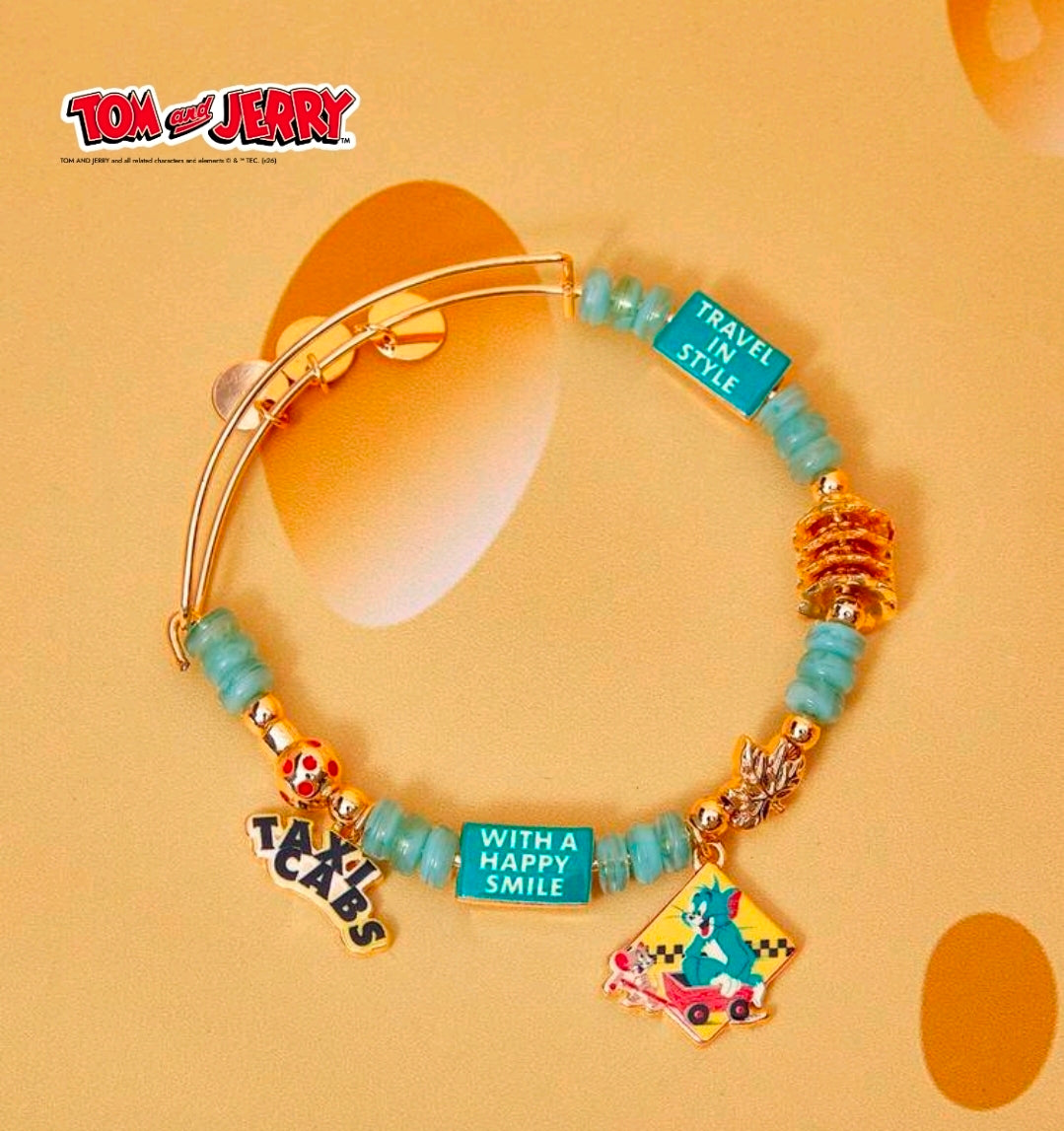 Gold-tone teal bead charm bangle bracelet with taxi cab, travel bottle, and happy smile tag
