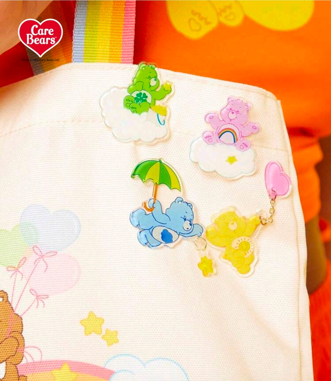 Acrylic cascading bear brooch pins on white tote bag with umbrella, cloud and star charms