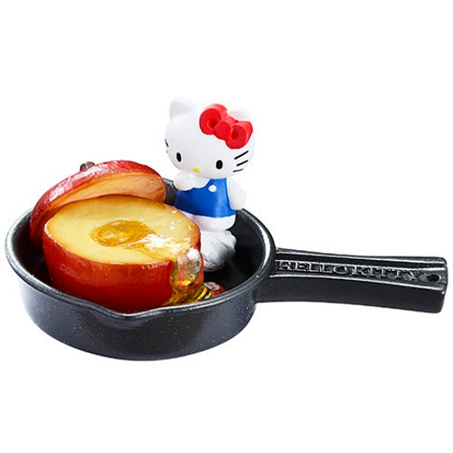 Hello Kitty mini figure holding baked apple in small skillet, red bow and blue dress