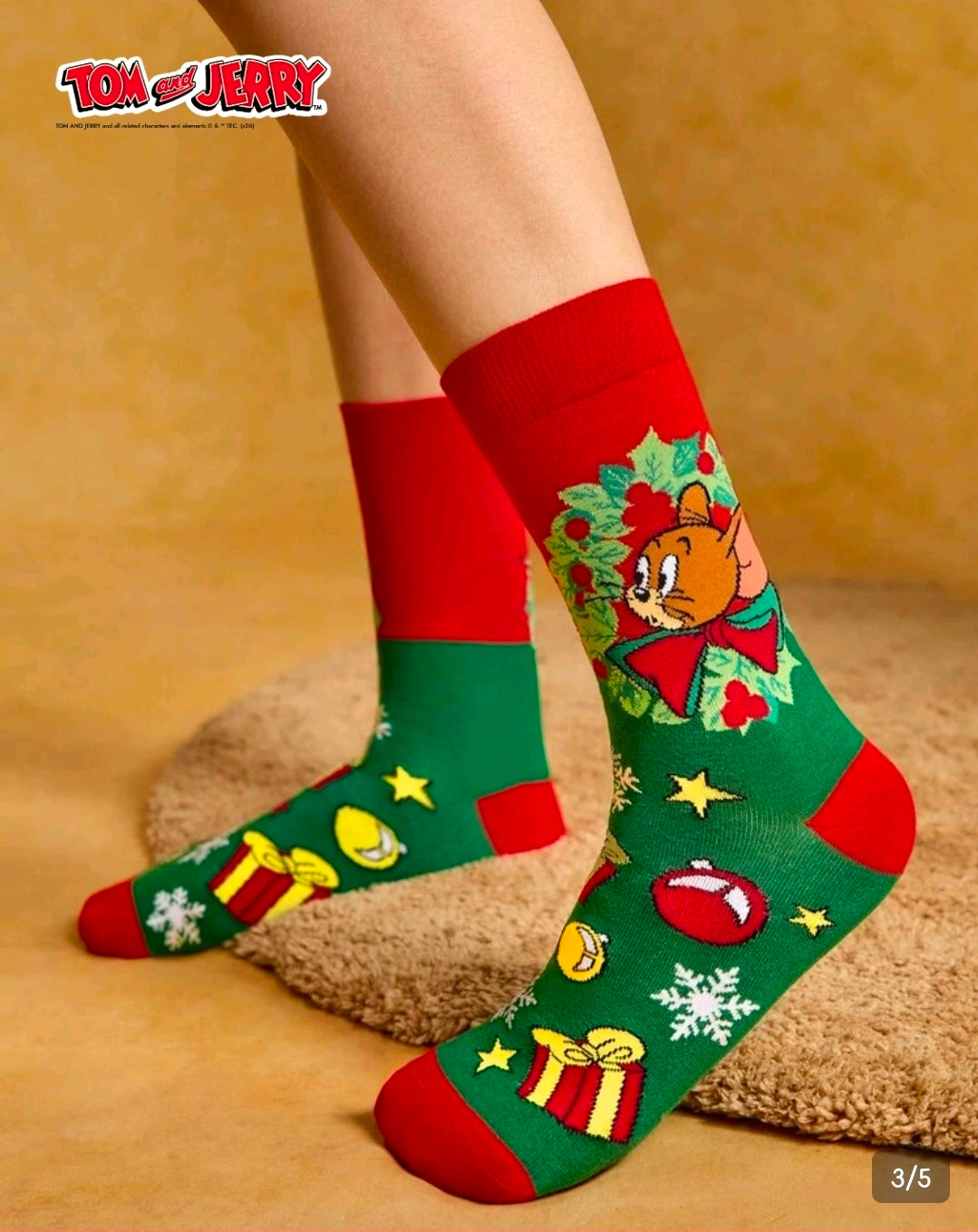 Tom & Jerry holiday crew socks on feet, green and red with festive icon pattern