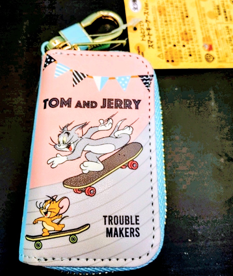 Pink Tom and Jerry smart key case with skateboard graphic and top zipper