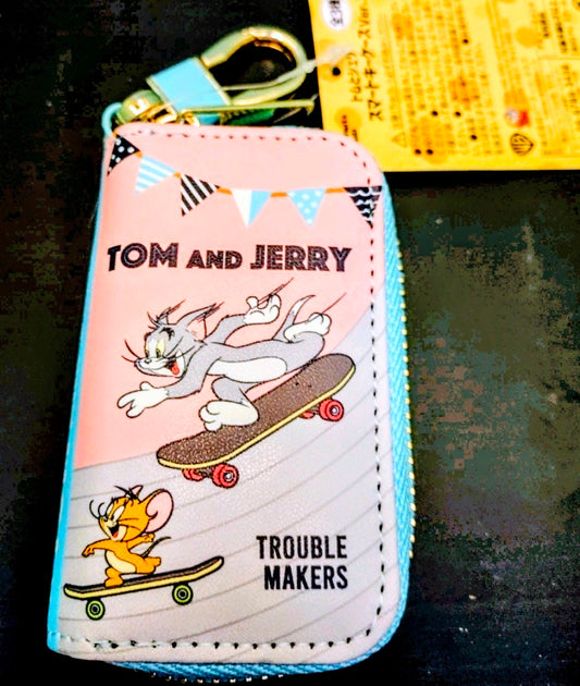 Pink Tom and Jerry smart key case with skateboard graphic and top zipper