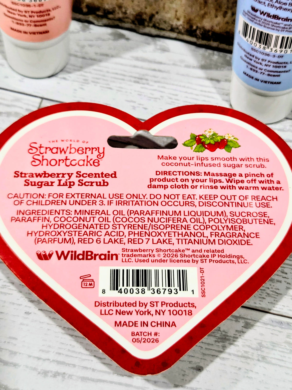 Heart-shaped Strawberry Shortcake lip scrub container with warning and ingredient text