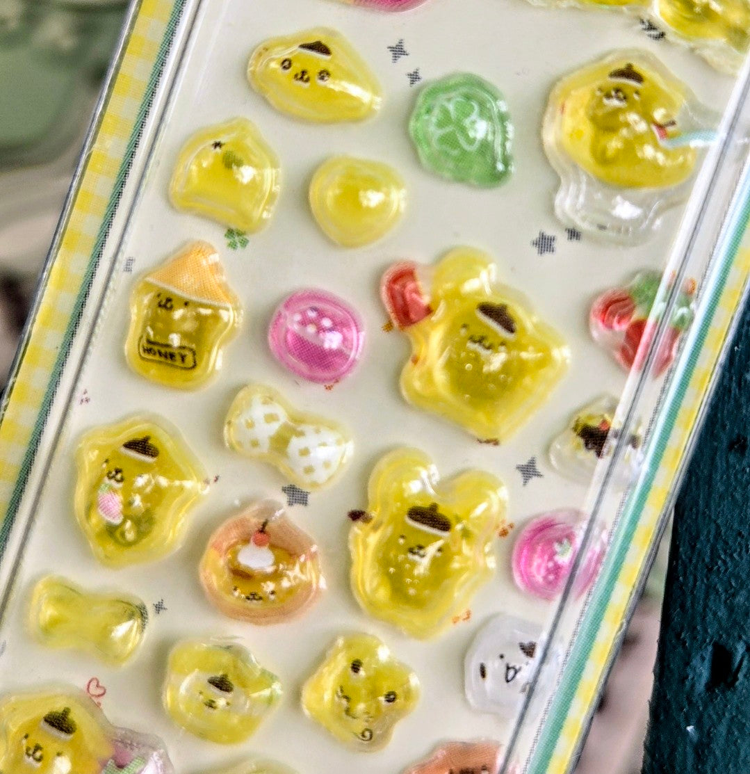 Clear blister pack of yellow 3D character stickers with a few green heart stickers