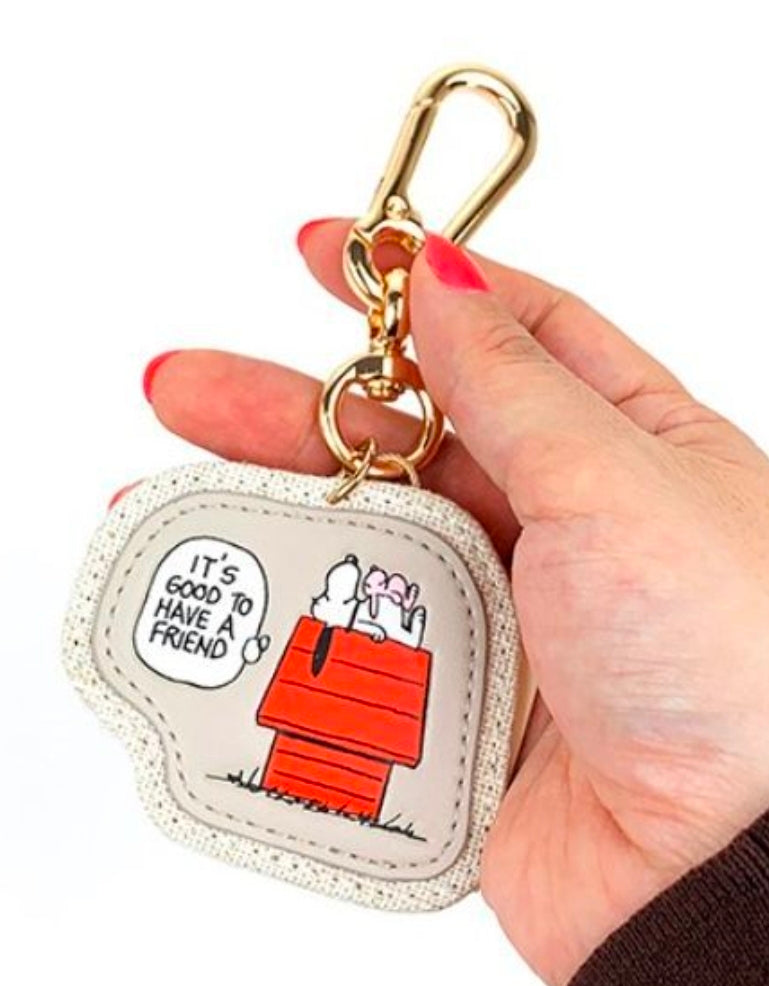 Fabric keychain fob with gold clasp, red doghouse graphic, held in a hand