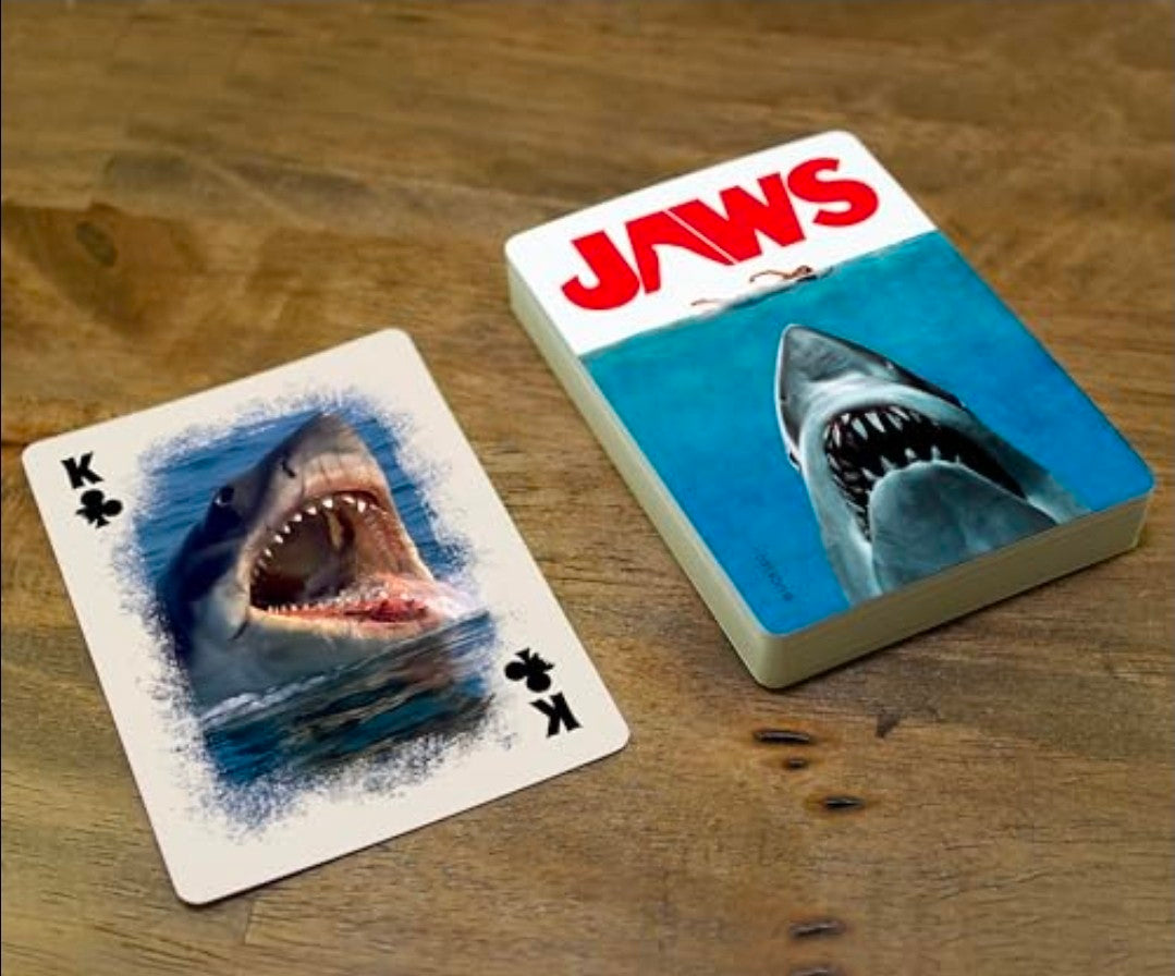 Aquarius Jaws playing cards deck with shark face cards on a wooden surface