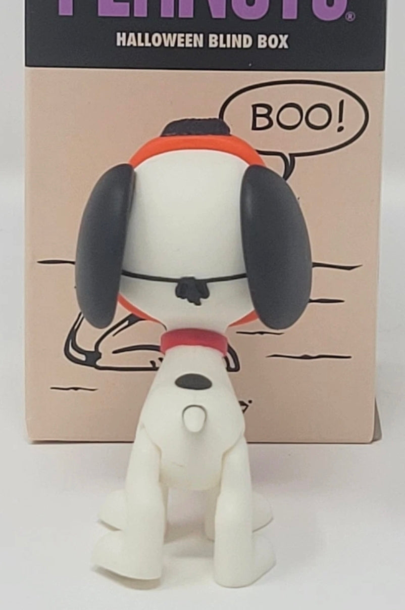 White dog Halloween blind box figure standing in front of tan cardboard packaging