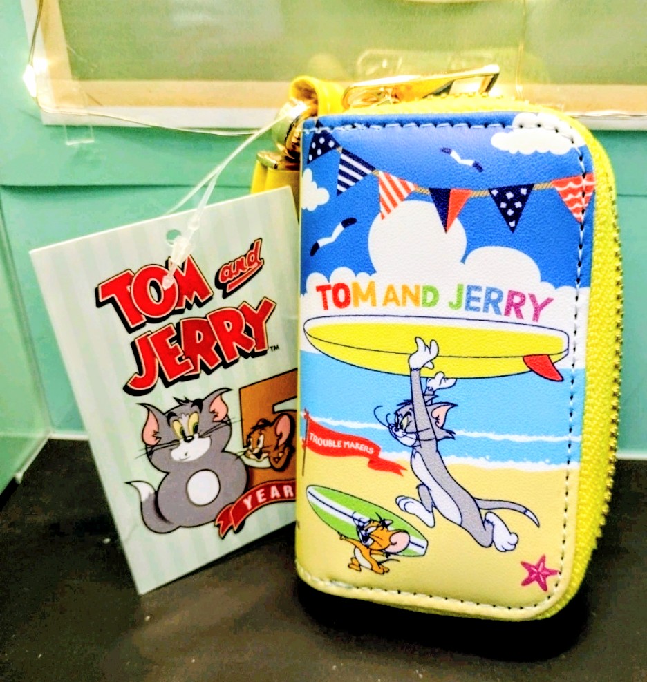 Blue smart key case with yellow zipper, Tom and Jerry surfboard artwork and tag