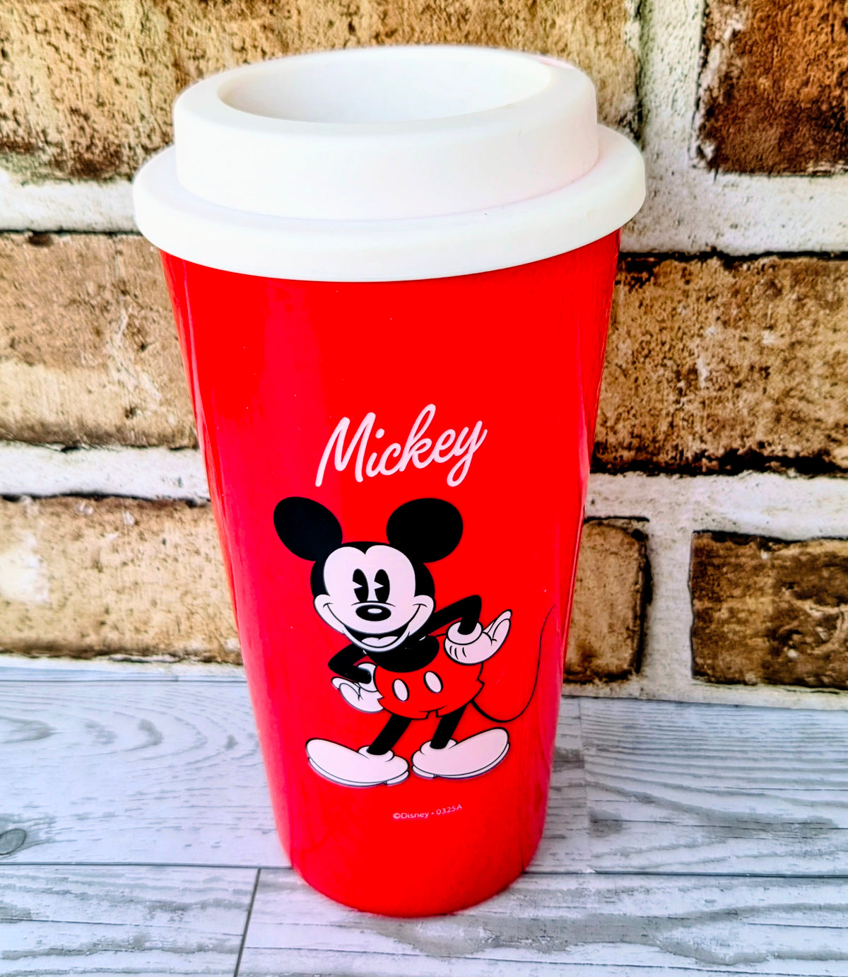 Red travel mug with white lid, Mickey Mouse graphic on front