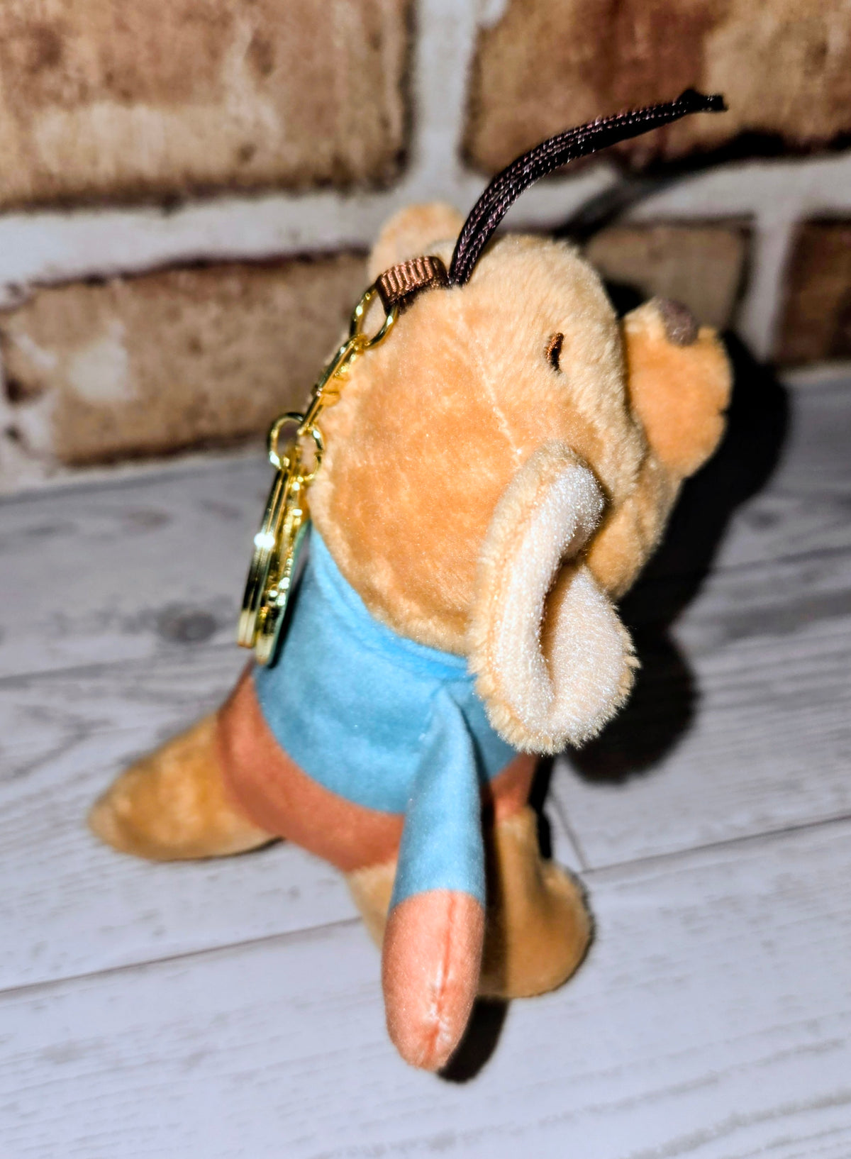 Roo mini plush keychain side view, blue shirt, orange plush face, black hanging loop