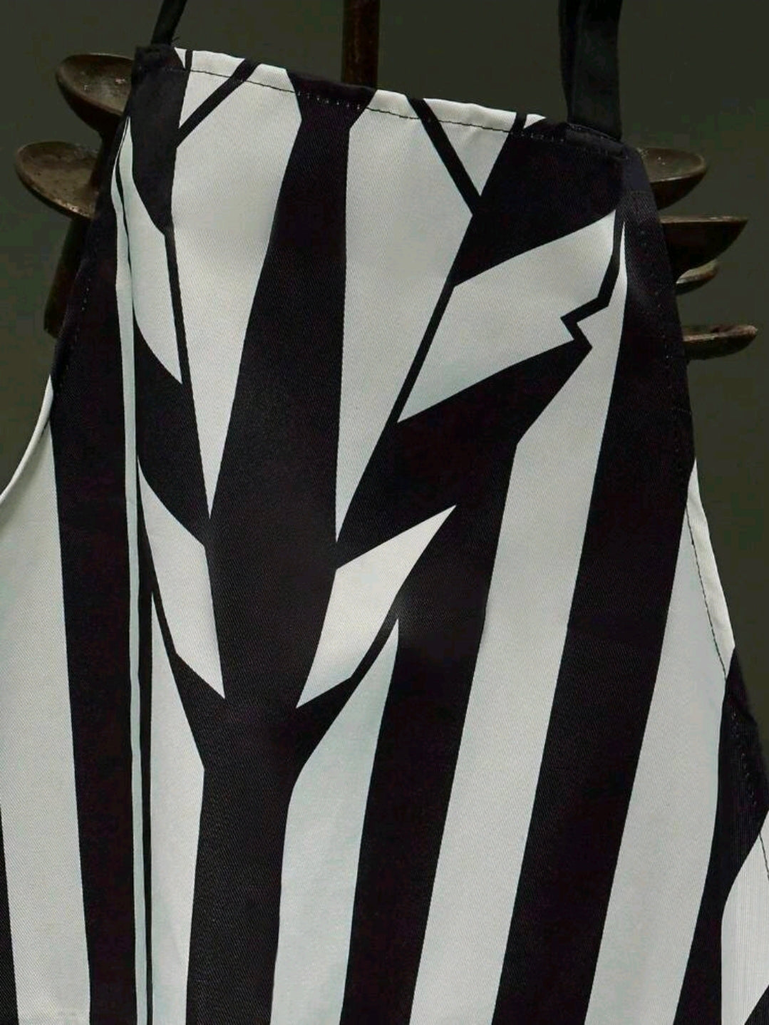 Black-and-white striped apron chest panel with jagged vertical graphic detail