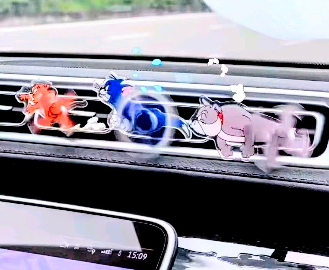Orange, blue, and pink cartoon character acrylic air-vent spinner clips on vent strip.