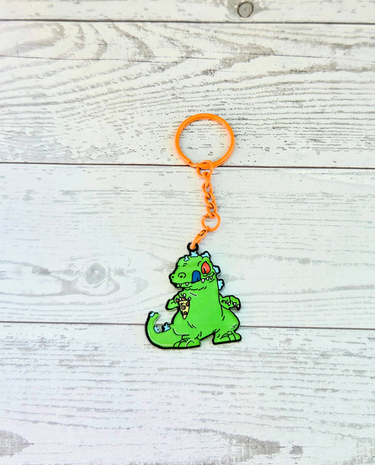 Orange-ring acrylic keychain with a small green Reptar crouching on orange chain
